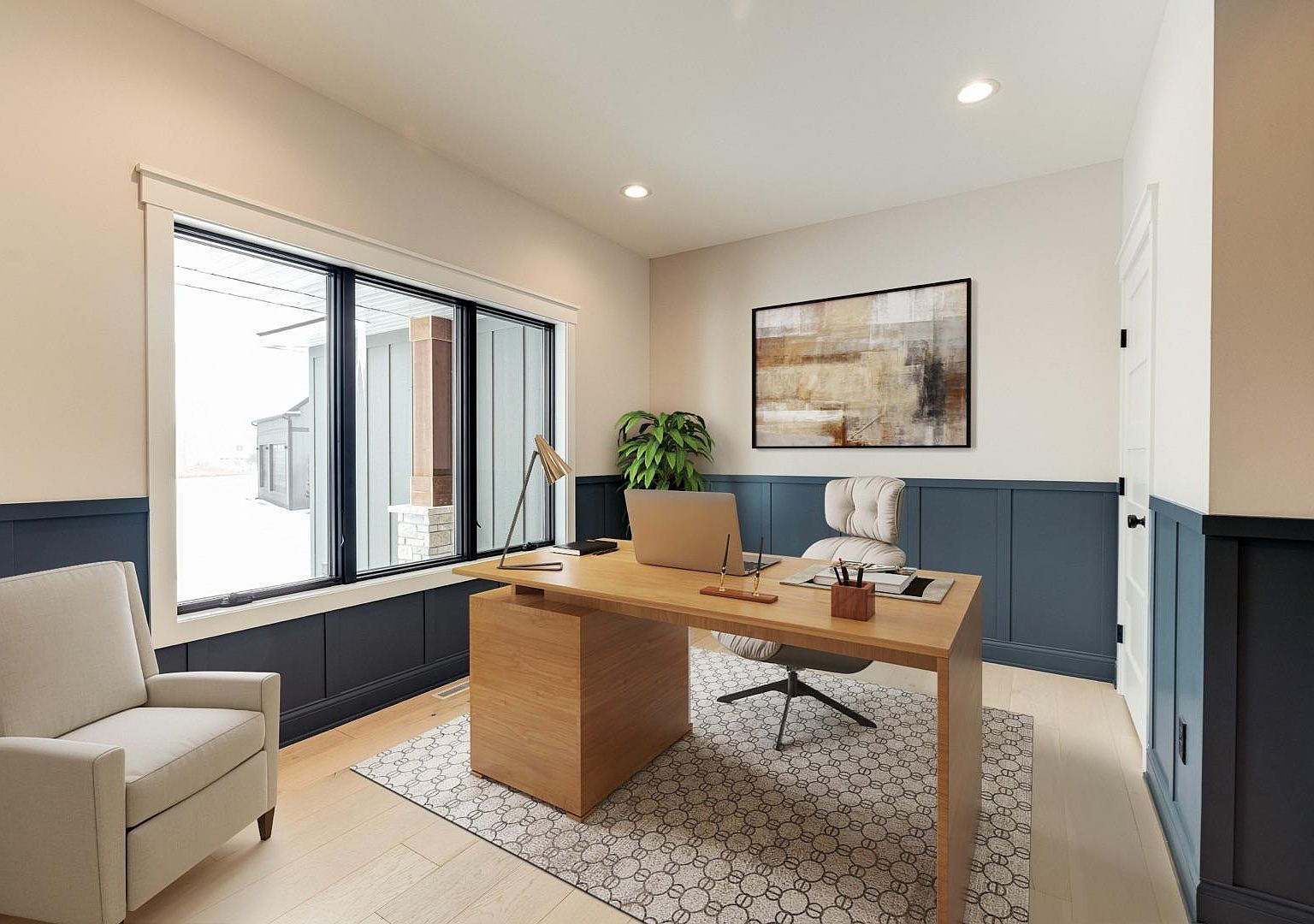 The main-floor private office at 2762 Mayo Prairie: navy-blue board-and-batten wainscoting, a stained wood desk, brass task lamp, a large abstract painting, and a wide window overlooking the side yard