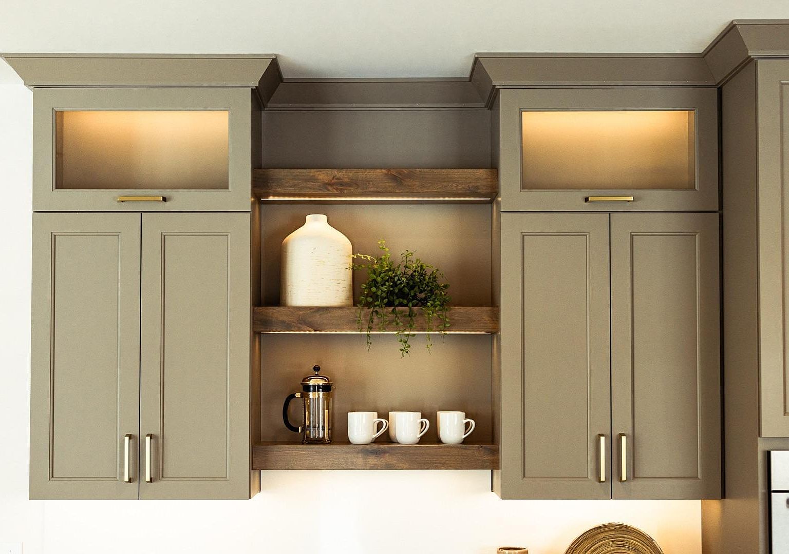 The butler's pantry adjoining the kitchen at 2762 Mayo Prairie: warm-gray shaker cabinetry, brass pulls, a stained-wood floating shelf, a beverage refrigerator, and double wall ovens